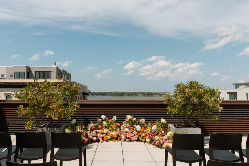 Rooftop wedding ceremony with colorful flowers and a view of Louisville.